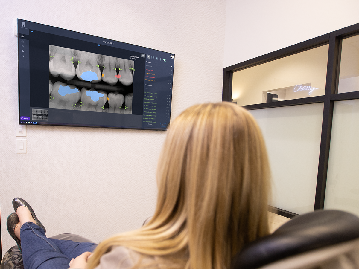 Patient views X-ray with dental AI analysis.